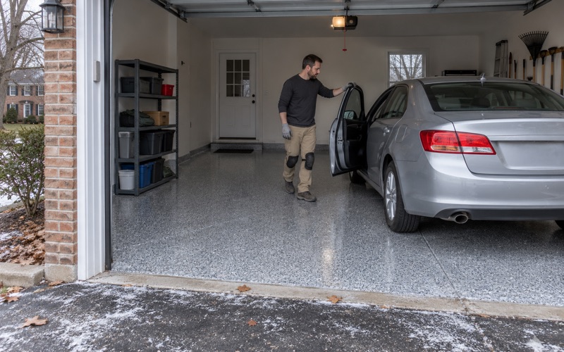 A car rolled back the same day onto a new polyaspartic flake floor in a Downers Grove garage on a cold late-autumn afternoon.